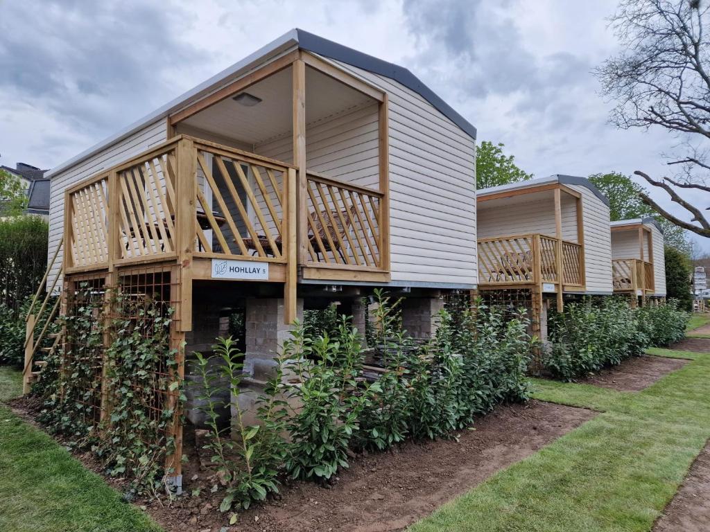 a modular home with a porch and a deck at Chalet Hohllay in Reisdorf