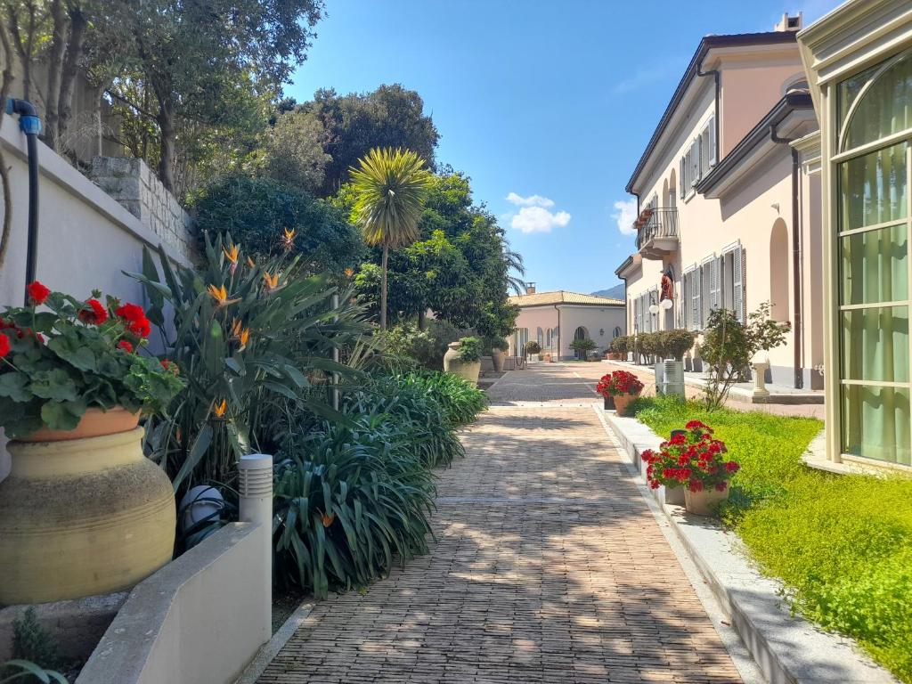 una strada acciottolata con fiori e piante di Villa Ersilia a Soverato Marina