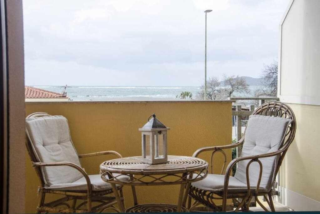 una mesa y sillas al aire libre con vistas al océano en Bilocale Fronte Mare Sparaglione en Sassari