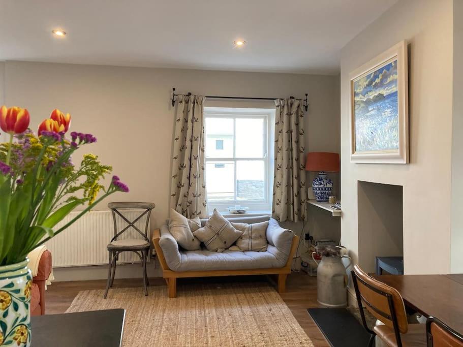 a living room with a couch and a window at Littlecot in Malborough