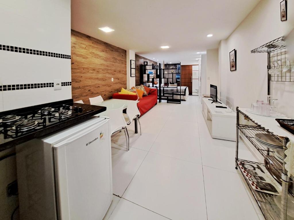 uma cozinha com um fogão e uma sala de estar em Flat Felipe de Oliveira no Rio de Janeiro