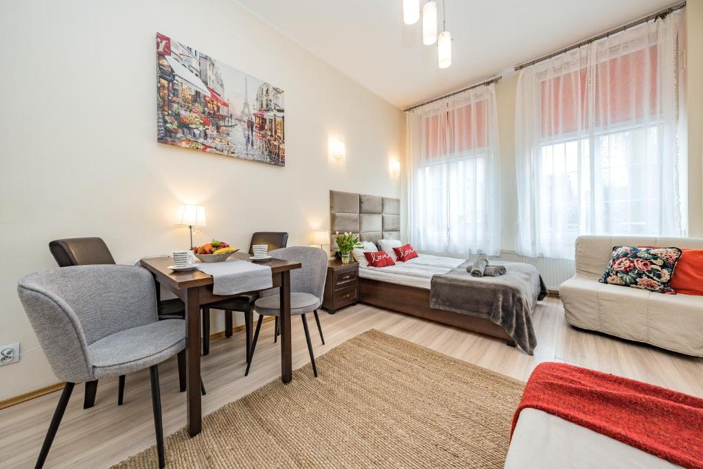 een woonkamer met een tafel en stoelen en een bank bij Apartamenty Przytulne Starówka Old Town Ogarna in Gdańsk