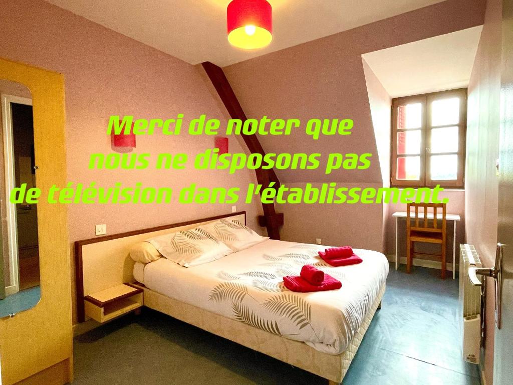 um quarto com uma cama com sapatos vermelhos em Auberge Le Beaulieu -Cantal em Beaulieu