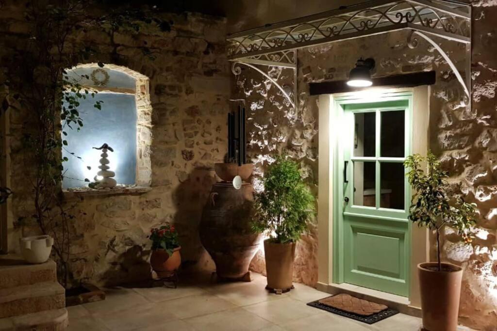 Nespola di Campiello في مدينة كورفو: غرفة بها باب أخضر ونباتات الفخار