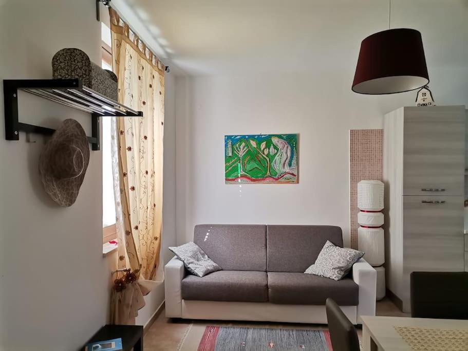 ein Wohnzimmer mit einem Sofa und einem Tisch in der Unterkunft Il nido di Angelina - Ascea in Ascea