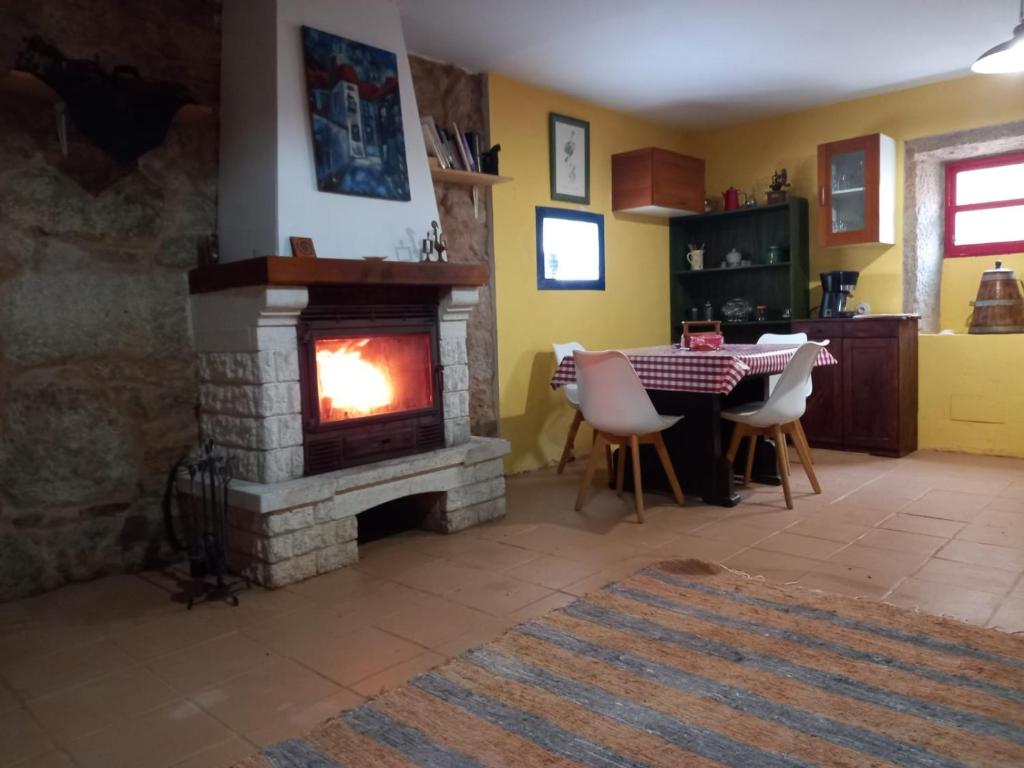 a living room with a fireplace and a table with chairs at A CASA de FLORINDA in Oia