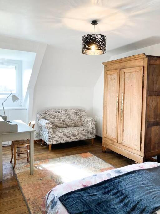 a bedroom with a couch and a chair and a desk at Maison de pêcheur rénovée (new) in Ploubazlanec