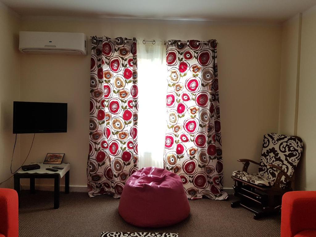 a living room with curtains and a chair and a window at Modern Apartment in Al Rehab City Center in Cairo