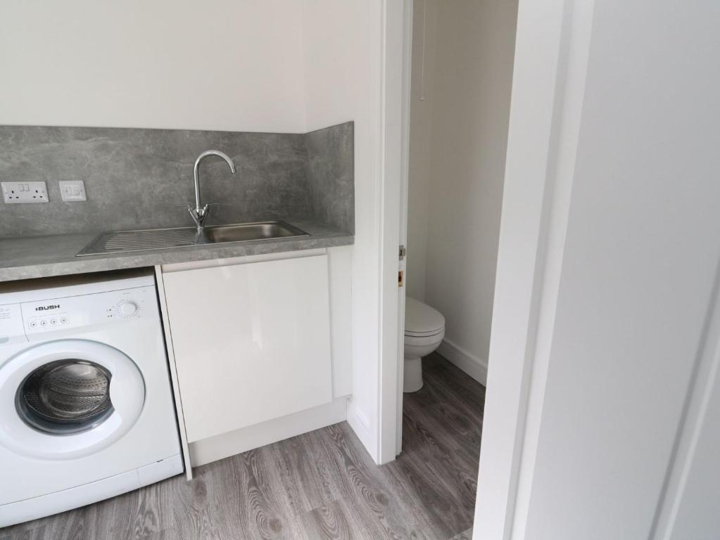 a laundry room with a sink and a washing machine at Borve House, Kilchoan in Kilchoan