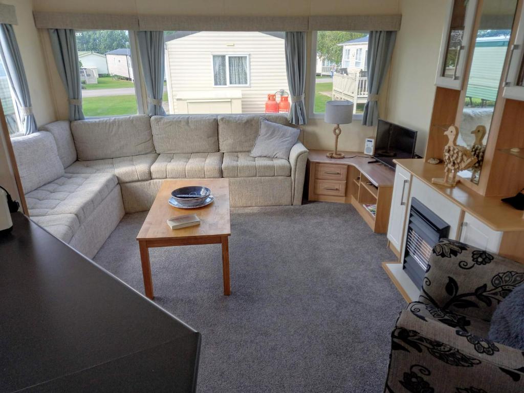 a living room with a couch and a coffee table at Sunny Hunny Manor Park Caravan in Hunstanton