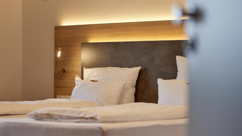 Moselhotel Weinhaus Simon في فينتريش: غرفة نوم بسريرين مع شراشف ووسائد بيضاء