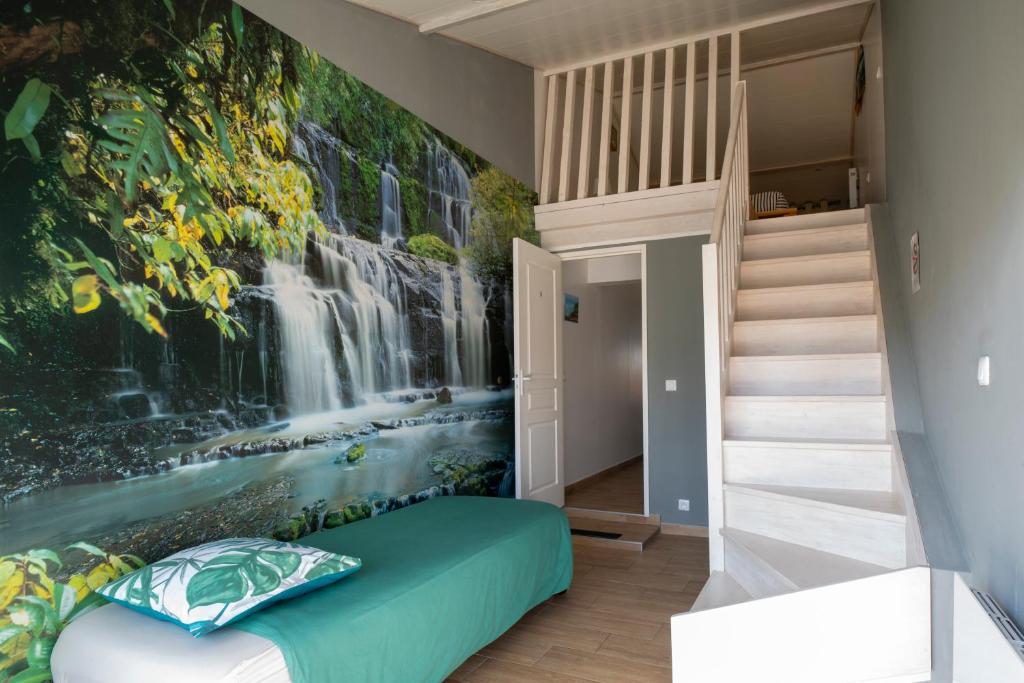 a bedroom with a waterfall mural on the wall at Charmant pavillon bordelais (logement entier) in Saint-Médard-en-Jalles