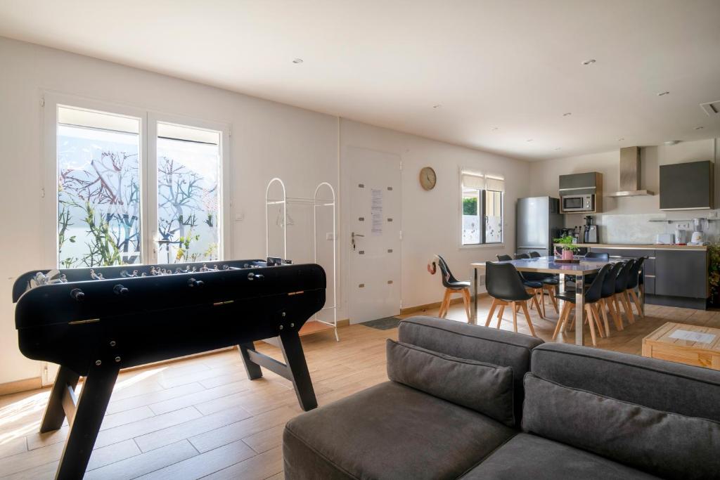 a living room with a couch and a pool table at Charmant pavillon bordelais (logement entier) in Saint-Médard-en-Jalles