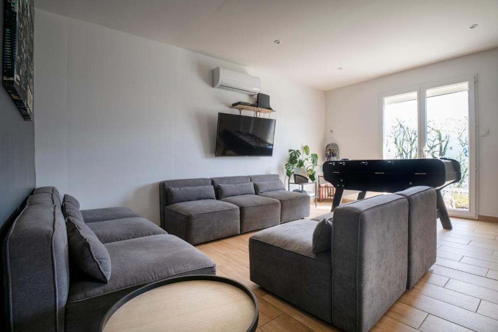 a living room with a couch and a piano at Charmant pavillon bordelais (logement entier) in Saint-Médard-en-Jalles