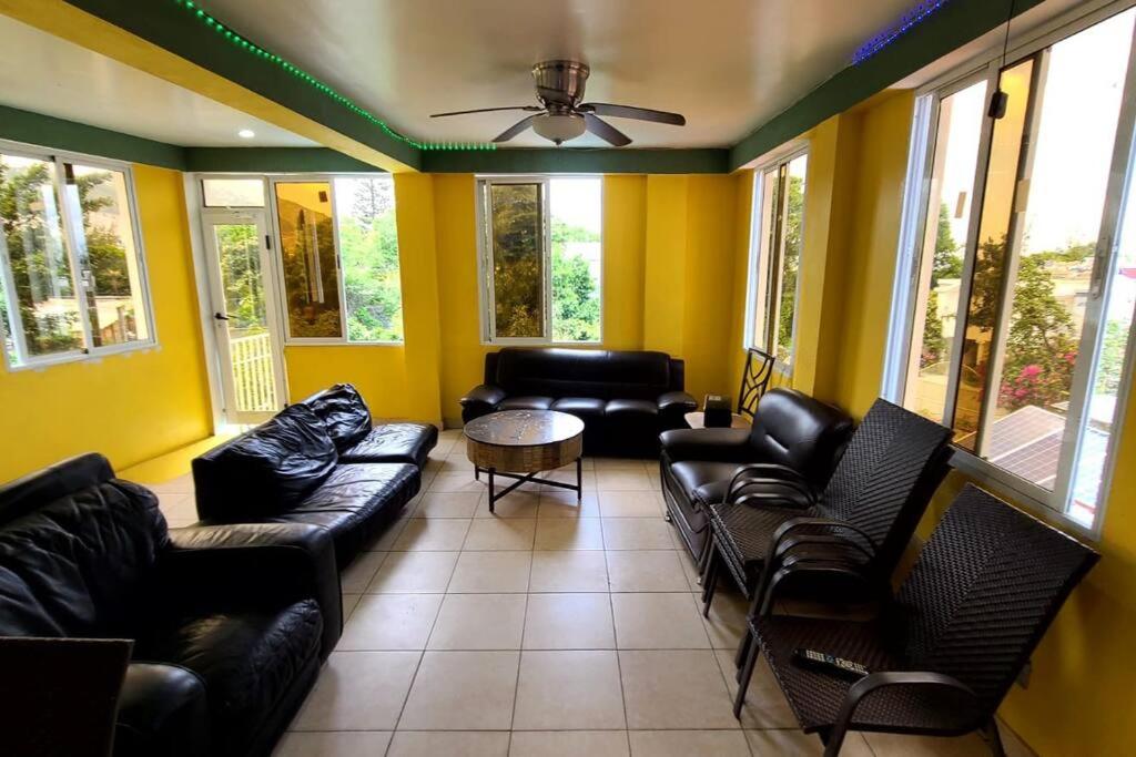 a living room with couches and a table and windows at 2 bedroom suite Peguyille 