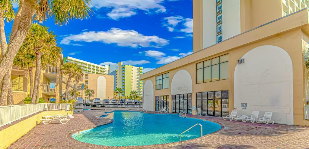 una piscina frente a un edificio con palmeras en Oceanfront Efficiency T902, en Myrtle Beach