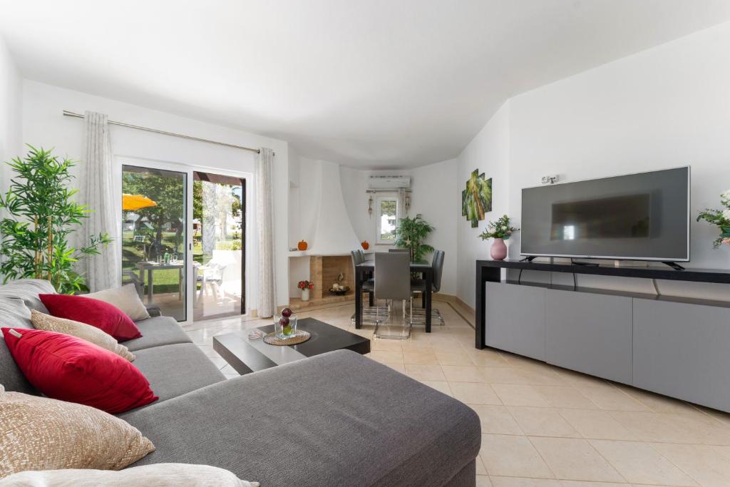ein Wohnzimmer mit einem Sofa und einem Flachbild-TV in der Unterkunft Balaia Golf Poolside Retreat - Superior 2 bed villa in Albufeira