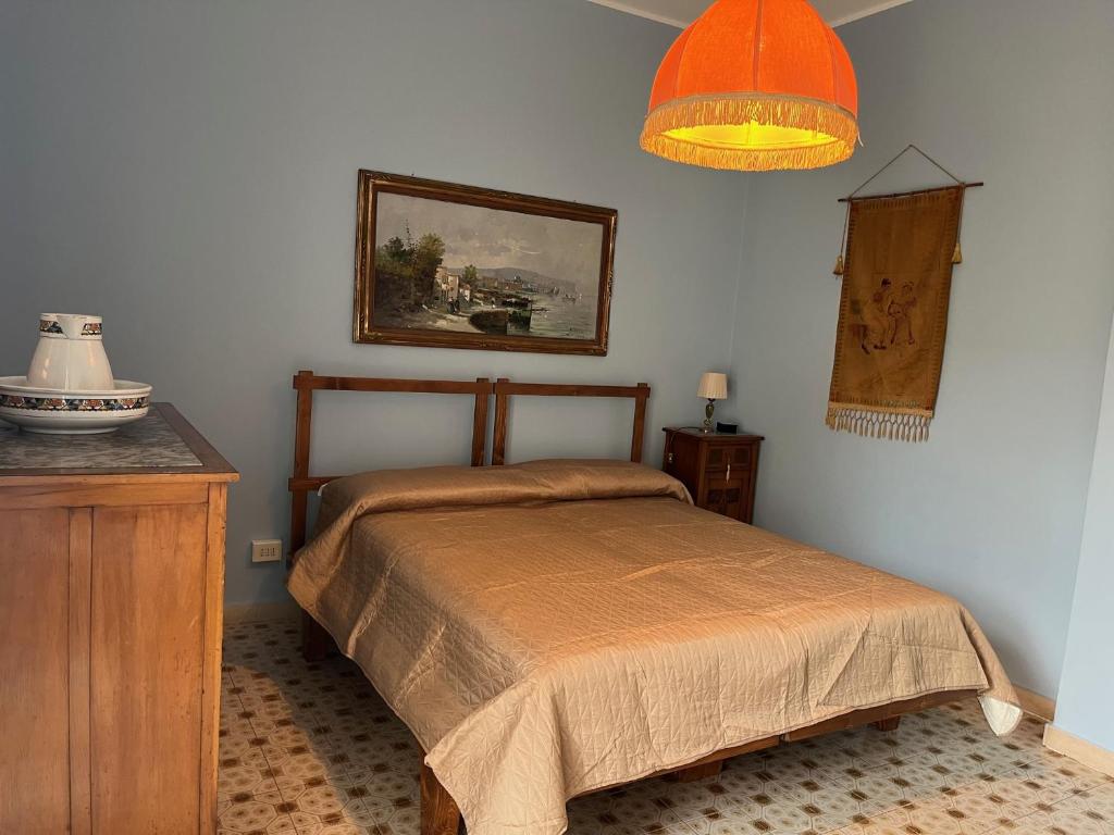um quarto com uma cama e um candeeiro na parede em Il tesoro di Fea em Giardini Naxos