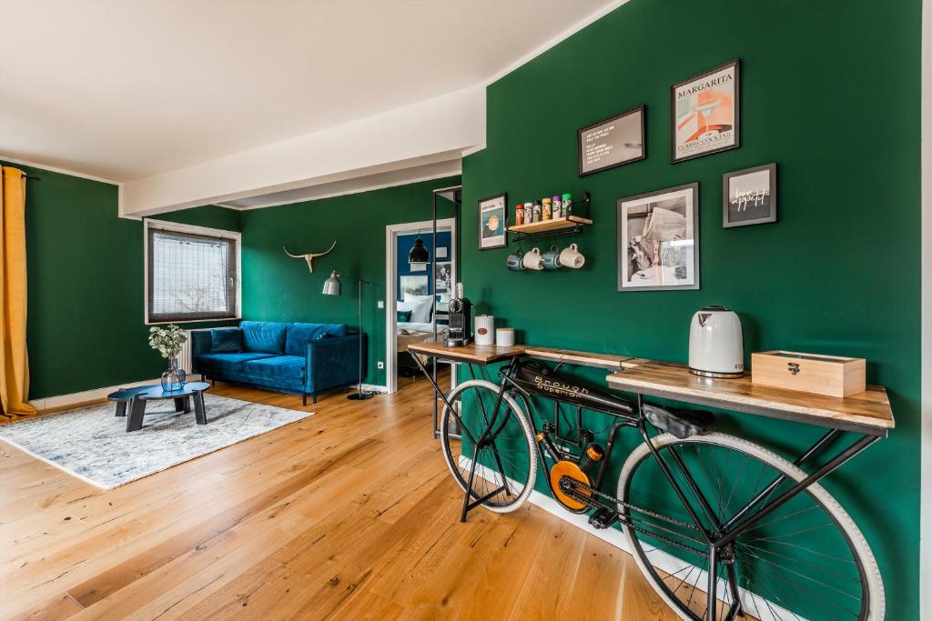 Cette chambre est dotée d'un mur vert avec un vélo. dans l'établissement Klassen Stay - Exklusives Apartment - Zentral und 4km zur Messe -Kingsizebett, à Essen