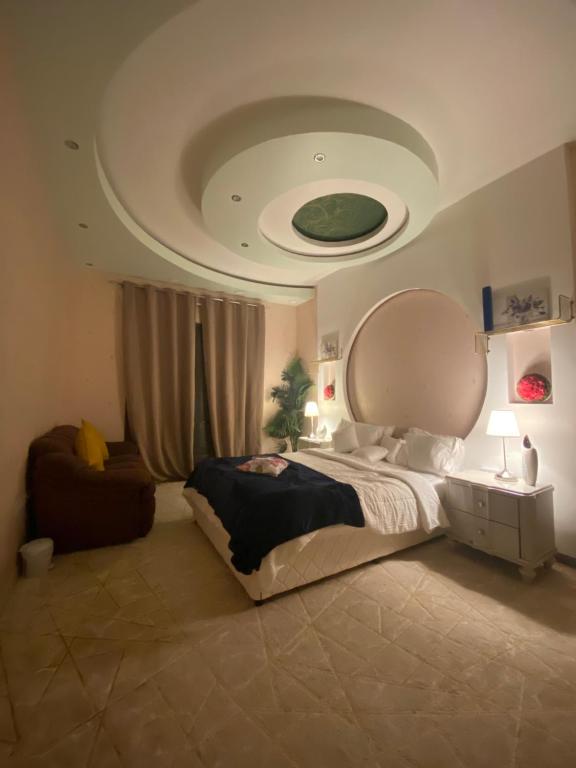 a bedroom with a large bed and a circular ceiling at ميناء الفجر in Rūl Ḑadnā
