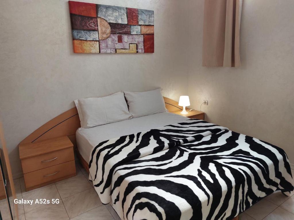 Ce lit se trouve dans un dortoir doté d'une couverture zébrée. dans l'établissement Appartement entier à une chambre à coucher, à Agadir