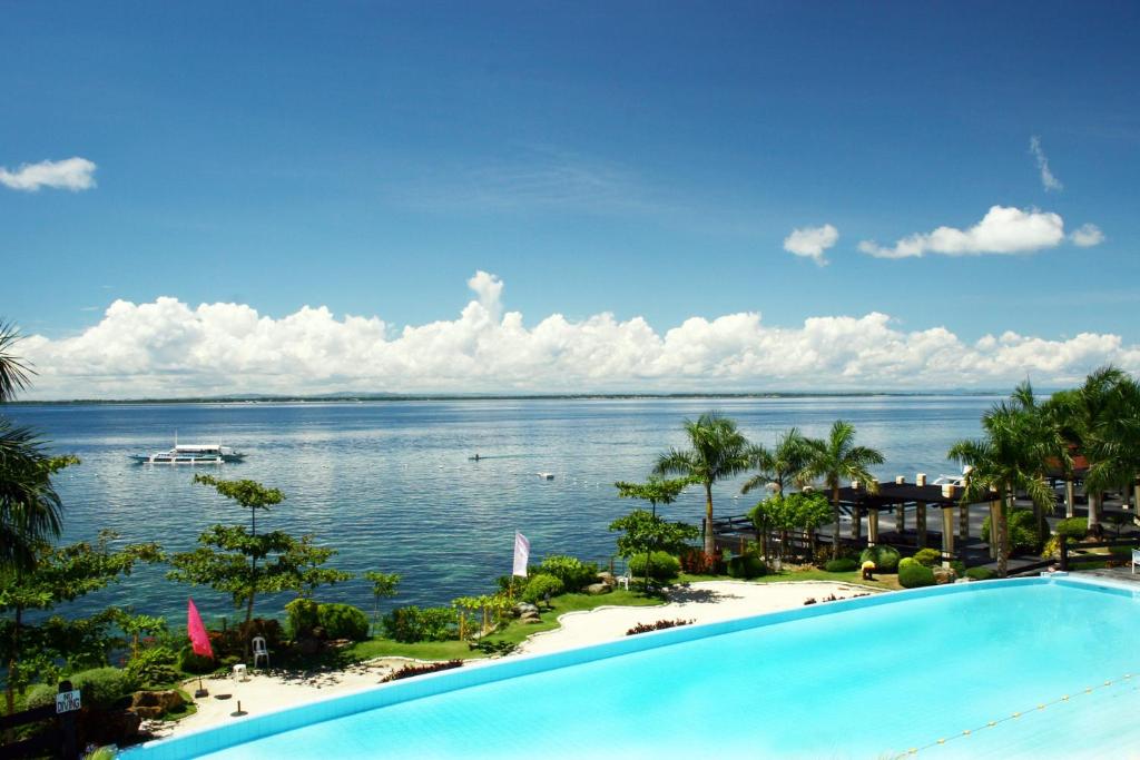 a swimming pool with a view of the ocean at Mactan Island Condo La Mirada Residence , Beach resort , Large 1 bedroom , pools , Ocean views, fast WiFi , Netflix in Mactan