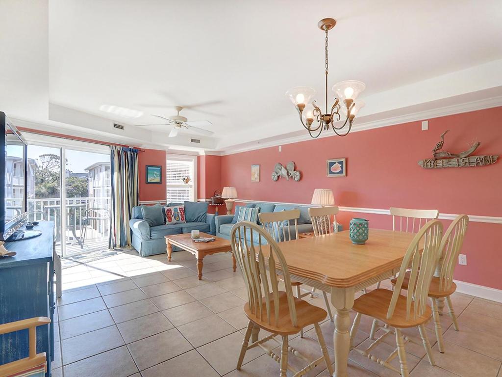 a dining room and living room with a table and chairs at Beachside Colony in Tybee Island