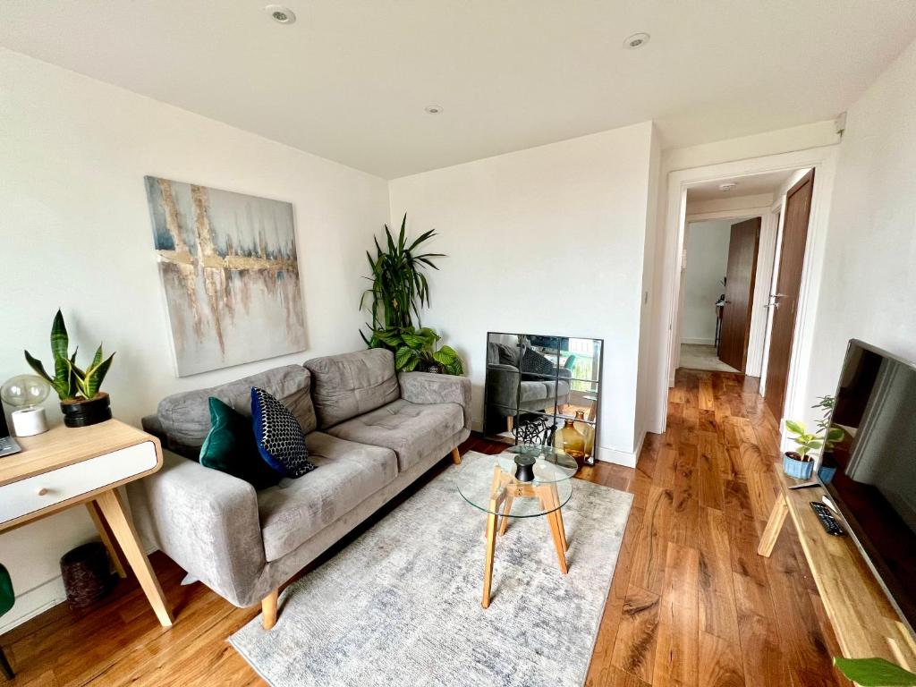 a living room with a couch and a tv at The Loft Queens Park in London