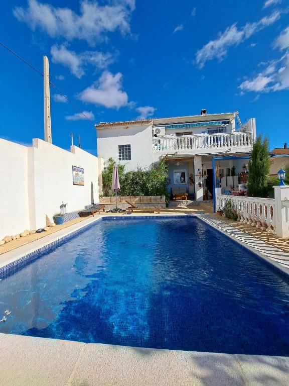 a swimming pool in front of a house at Casa de los Suenos Granada in El Turro