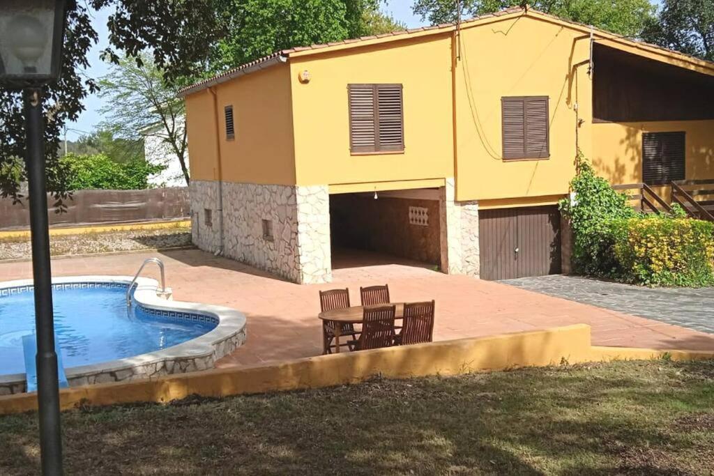 un bâtiment jaune avec une piscine et une maison dans l'établissement Casa independiente , piscina, naturaleza y relax, 