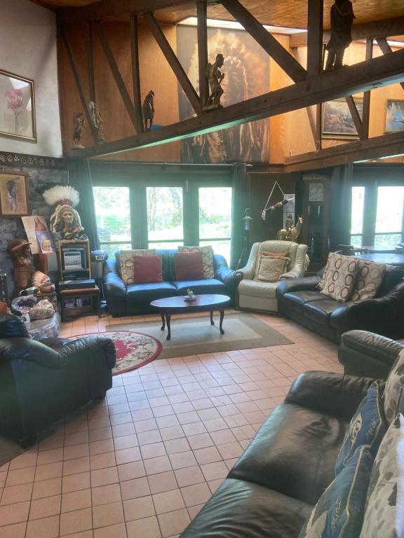 ein großes Wohnzimmer mit Sofas und einem Tisch in der Unterkunft Haven of Trees - Hafan Y Coed in Abercraf