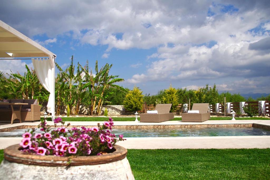 un complejo con piscina y flores en un patio en Private Villa Freedom, en Moírai
