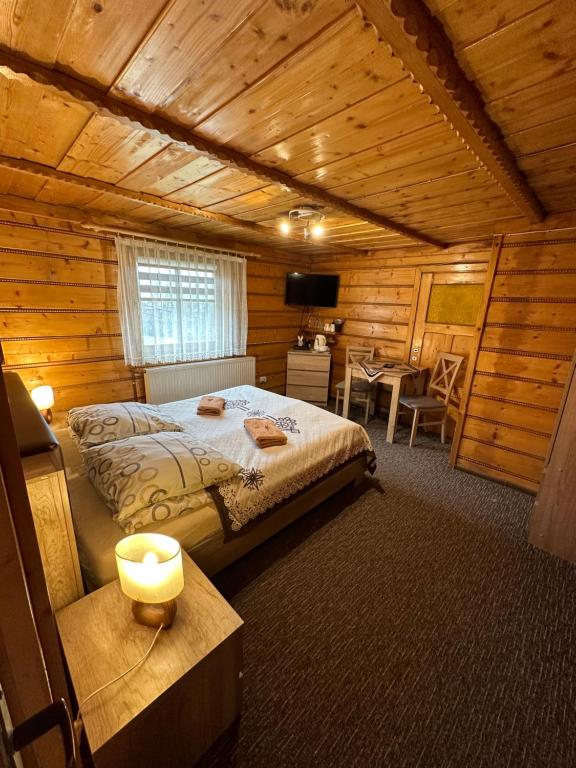 sypialnia z łóżkiem w drewnianym domku w obiekcie Willa Pod Stokiem w Zakopanem