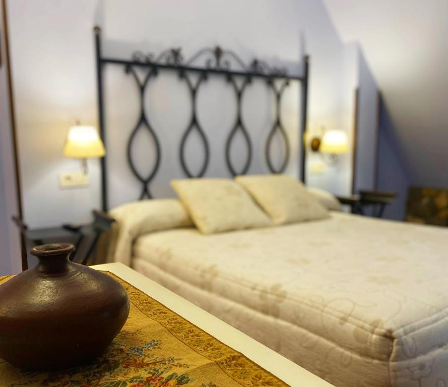 um quarto com uma cama e um vaso sobre uma mesa em La Llosa de Sámano em Castro-Urdiales