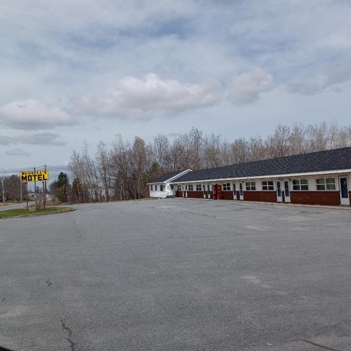 un parcheggio vuoto di fronte a un edificio di Russell's Motel a Caribou
