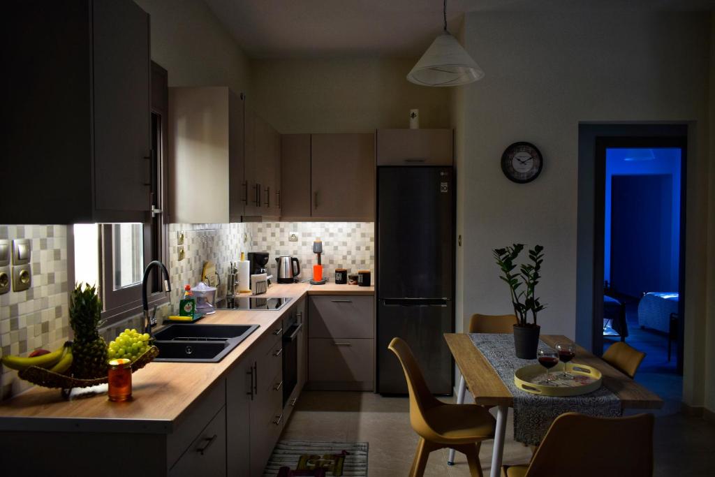 a kitchen with white cabinets and a black refrigerator at Dolphins House in Lixouri