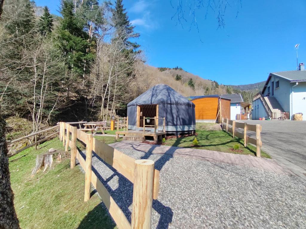 a yurt with a fence next to a road at Yourte des Verts Bois in Fréland