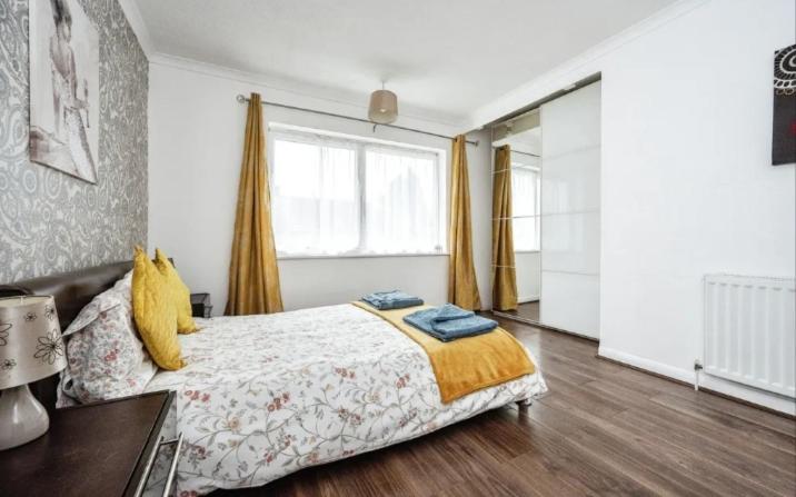 1 dormitorio con cama y ventana grande en Lovely 2 bedroom flat in Luton no kitchen facilities free parking, en Luton