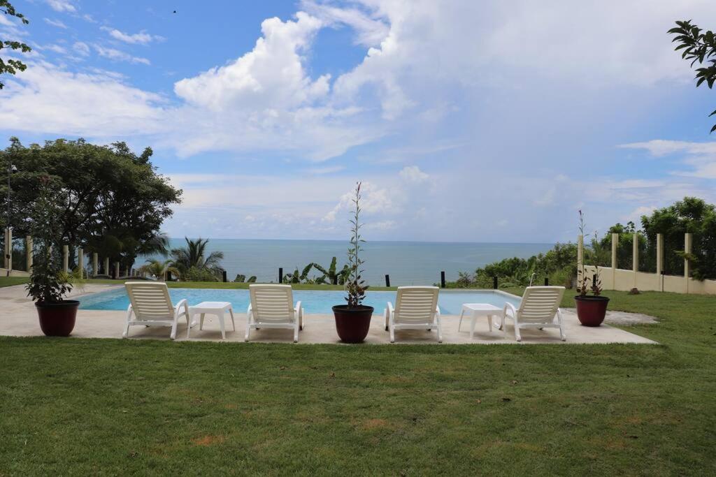 um grupo de cadeiras brancas sentadas ao lado de uma piscina em Secluded Ocean Front Overlooking the Marina em San Carlos
