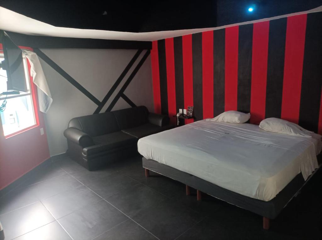 1 dormitorio con cama y sofá en La Selva Auto Hotel ADULTS ONLY en Soncuantla
