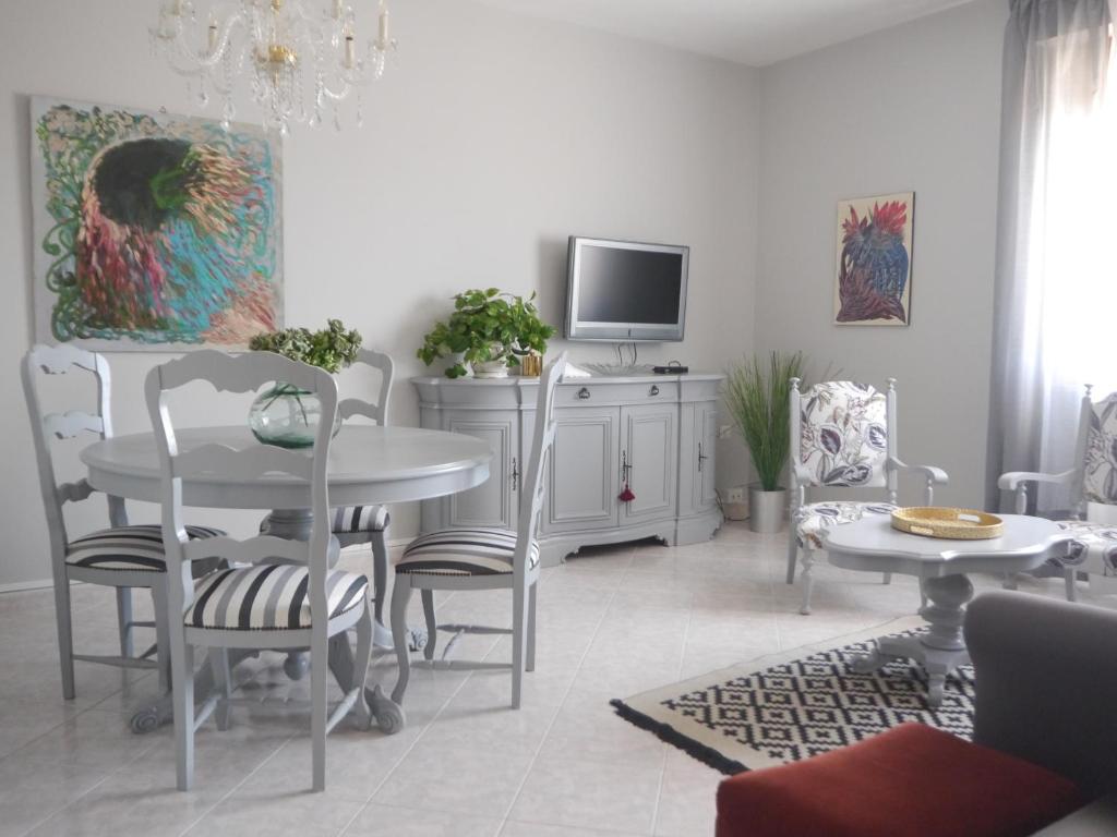 a living room with a table and chairs and a tv at Domus Tilla in Piombino