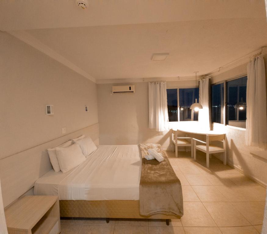 Un dormitorio con una cama y una mesa. en Não Disponível, en Florianópolis