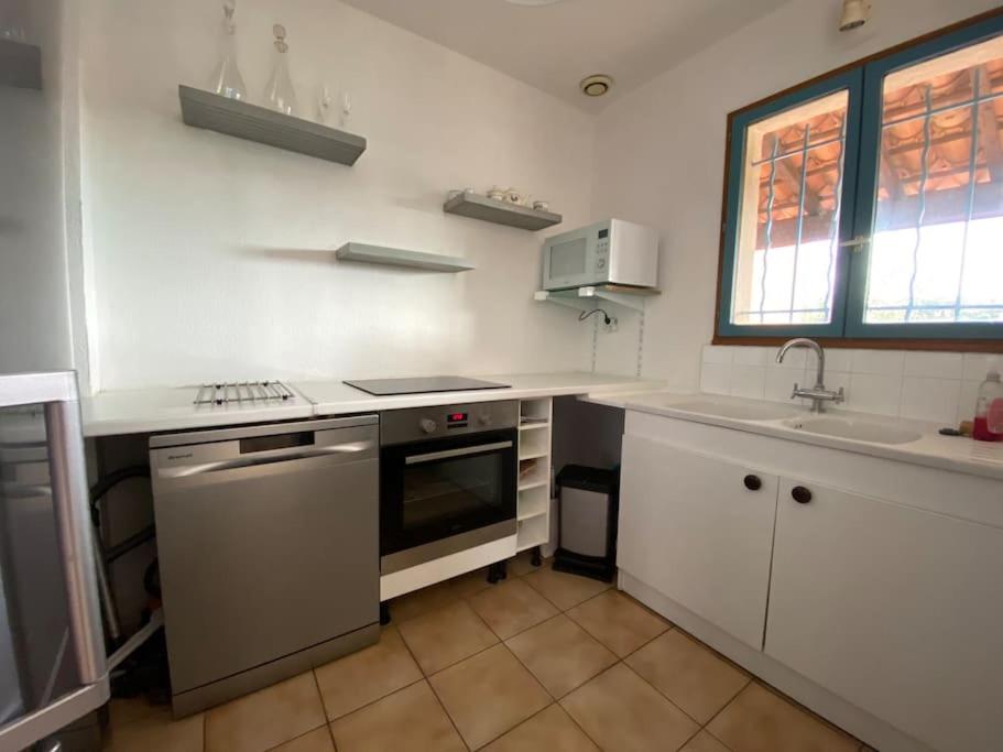 a kitchen with a sink and a stove top oven at small house 6p in bormes, quiet , hill-view in Bormes-les-Mimosas