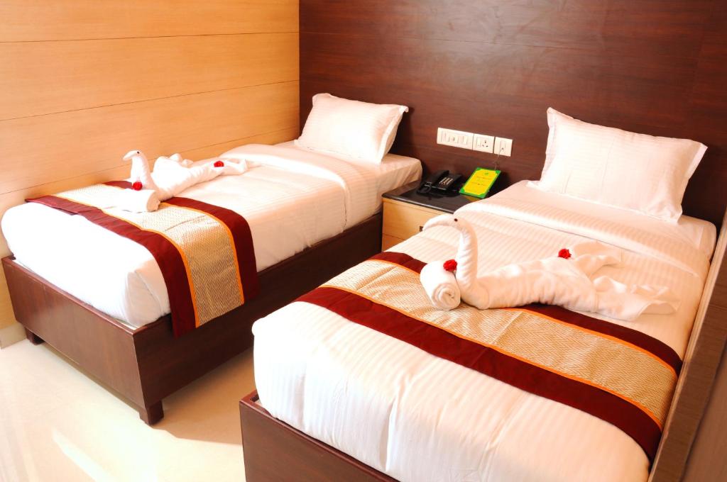 a room with two beds with stuffed animals on them at Sai Budget Hotel Chennai Airport in Chennai