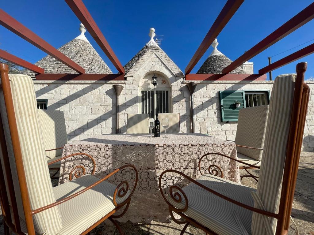 un patio avec des chaises et une table et un bâtiment dans l'établissement Trullo Trullallero, à Martina Franca