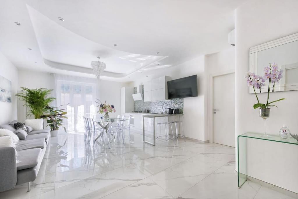 een woonkamer en een keuken met witte muren en witte vloeren bij Domus Delia Pescara Centro in Pescara
