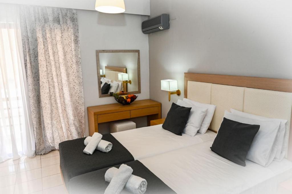 ein Hotelzimmer mit 2 Betten und Handtüchern darauf in der Unterkunft ANGELA STUDIOS in Kremasti