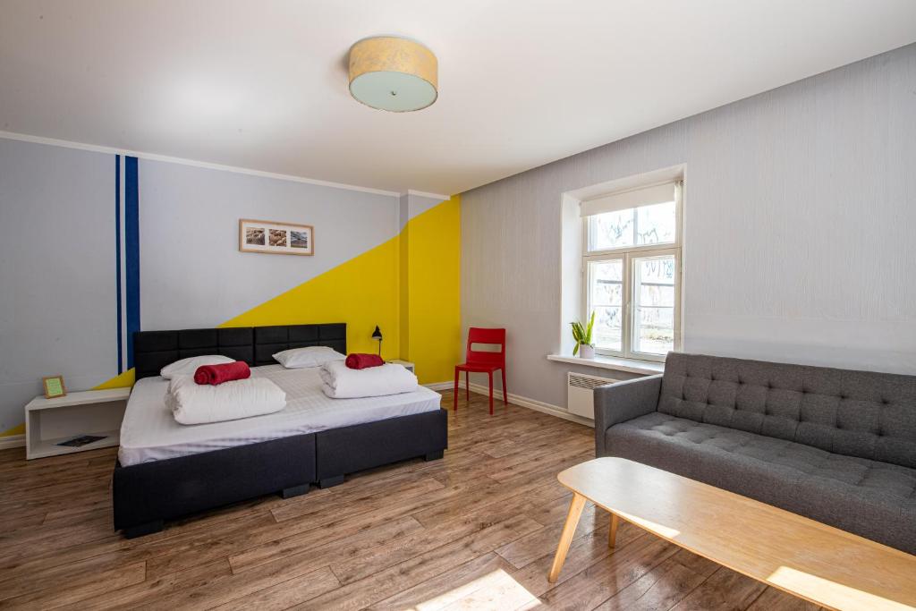 - une chambre avec un lit et un canapé dans l'établissement Tallinn Guest House, à Tallinn