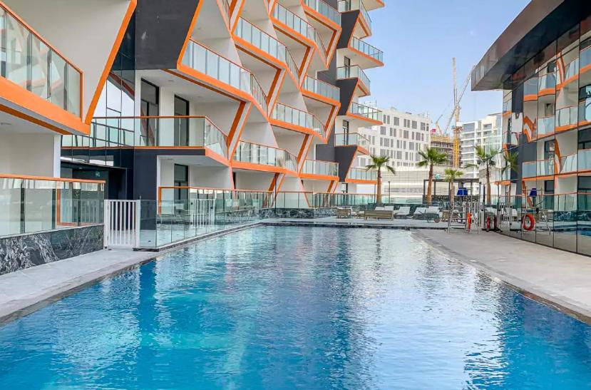 a swimming pool in front of a building at Hayyak Homes-Luxury 1 bedroom Apartment in Dubai