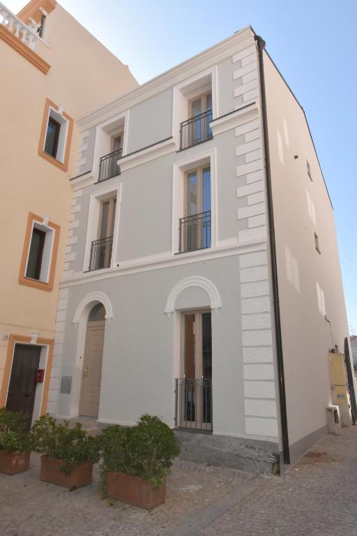a large white building with plants in front of it at CAVOUR ROOMS in Olbia
